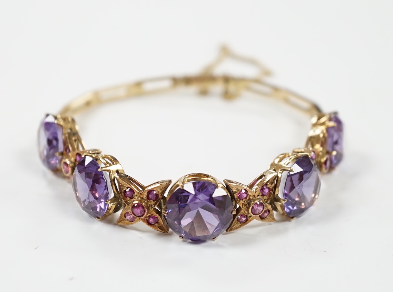 A yellow metal, synthetic colour change corundum and gem set bracelet. approx. 18cm, gross weight 22.7 grams.
